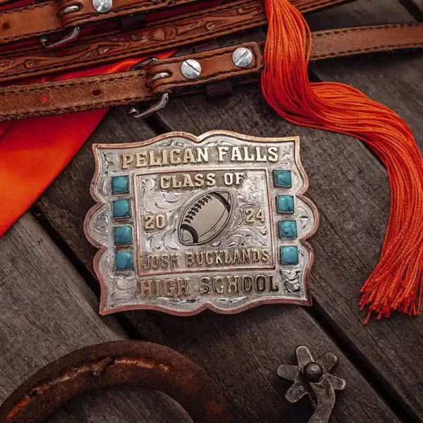 A custom silver and turquoise belt buckle for Pelican Falls High School featuring a football figure 